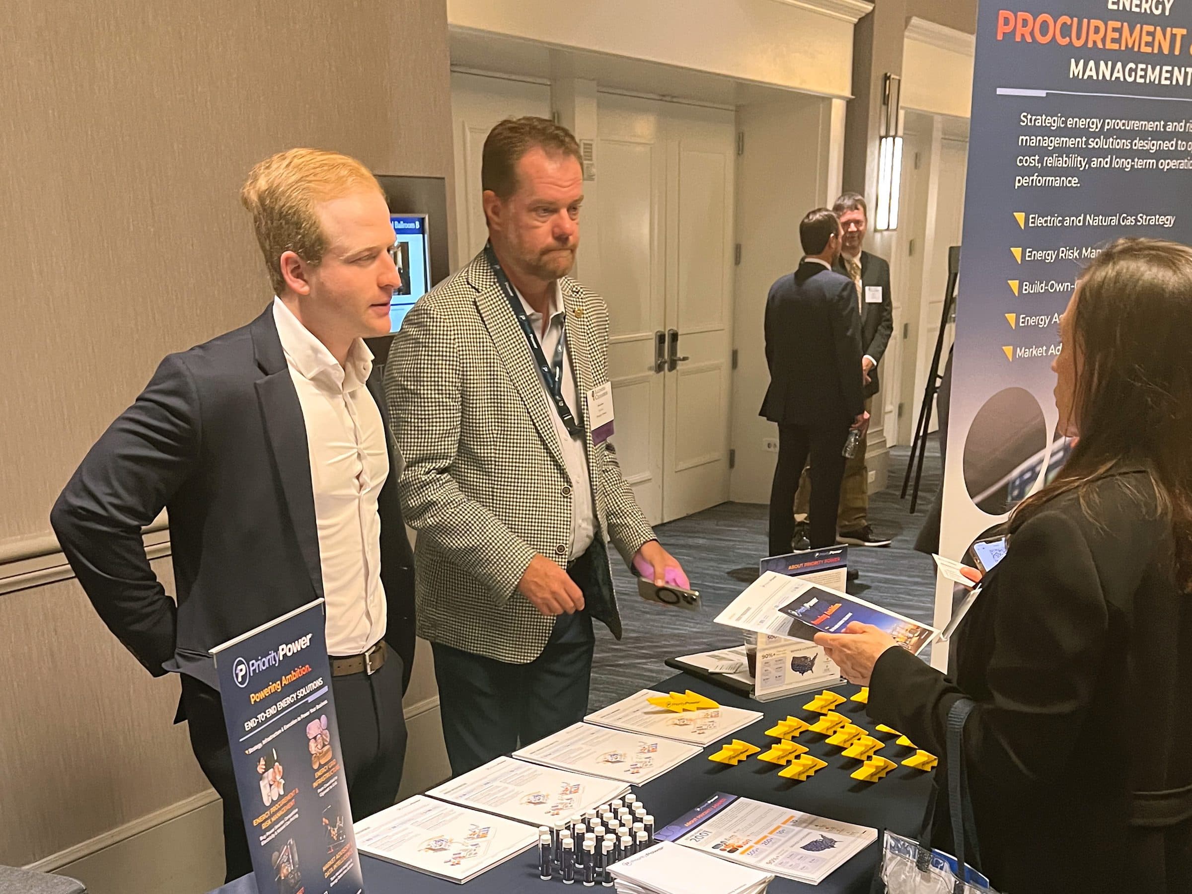 Attendees talk with exhibitors at an energy procurement table in the expo.