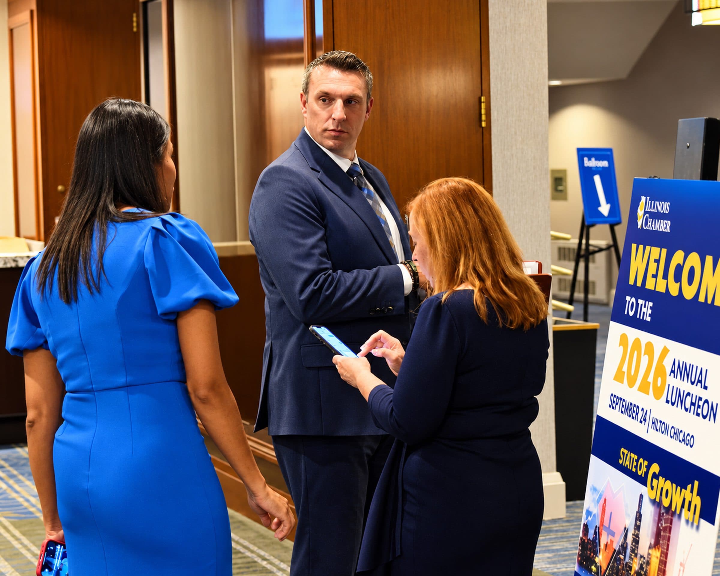 Guests chat beside the 2026 Annual Luncheon welcome sign.