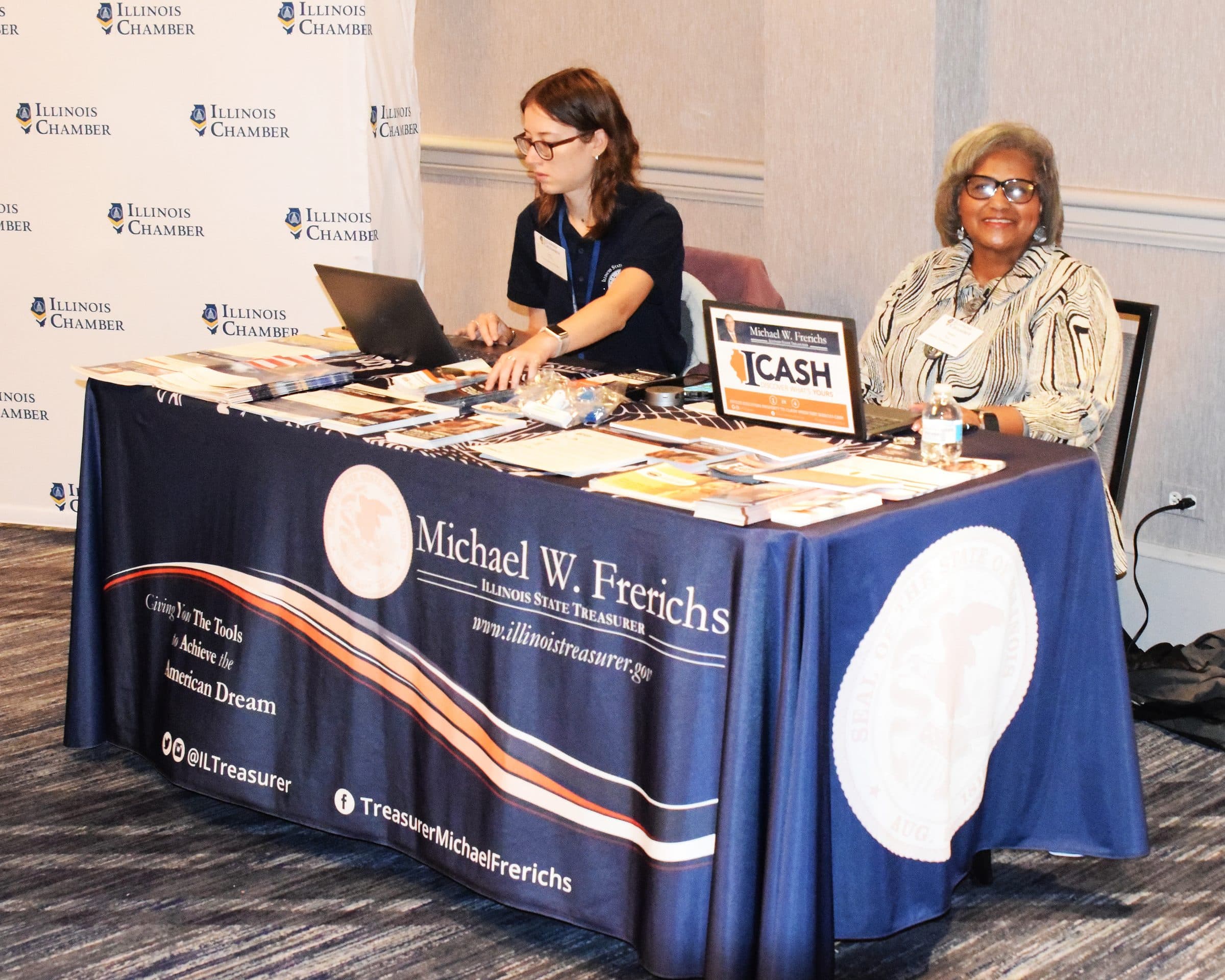 Two women staff the Illinois State Treasurer's exhibit table.