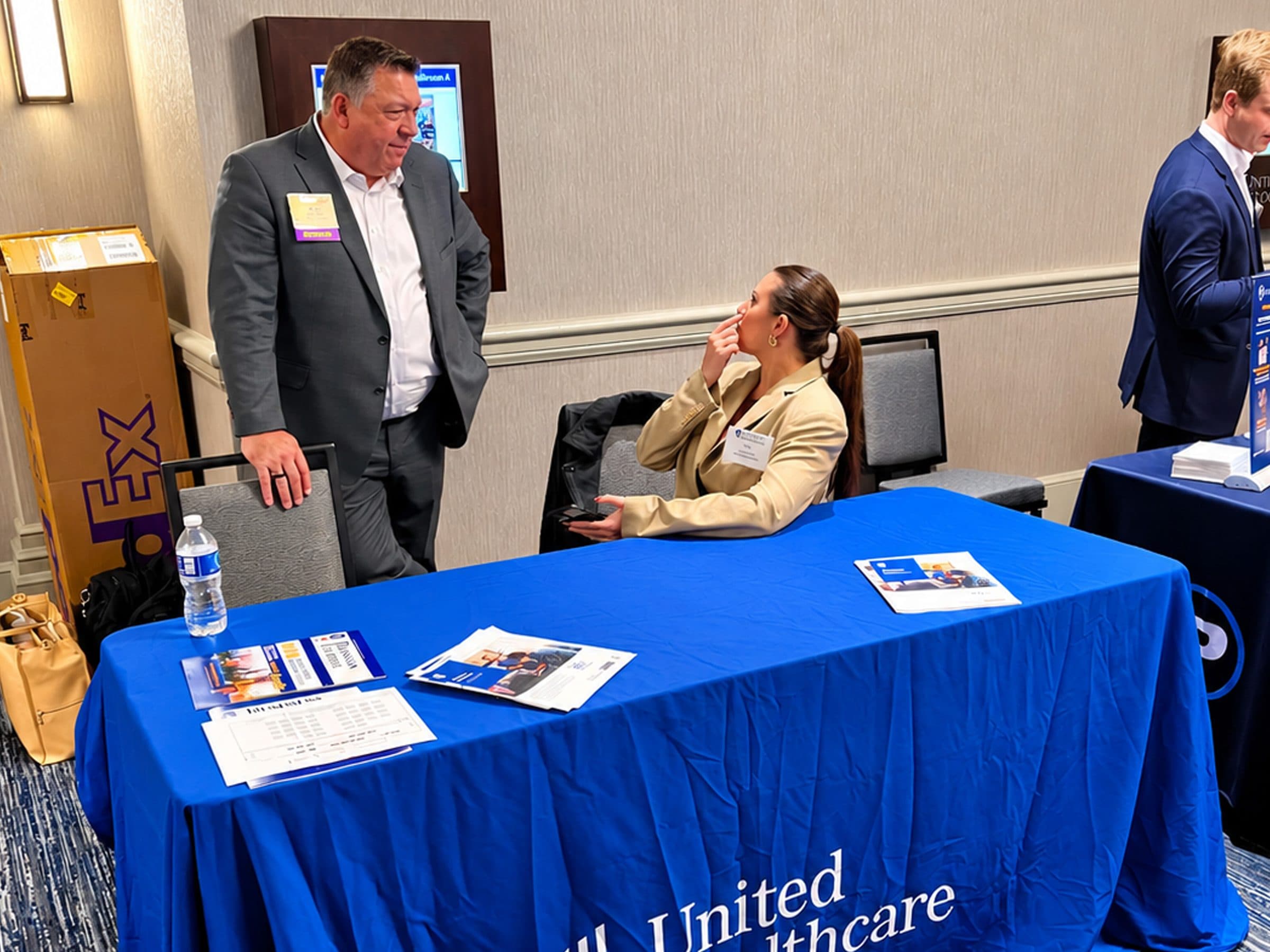 An exhibitor greets a visitor at the UnitedHealthcare table.