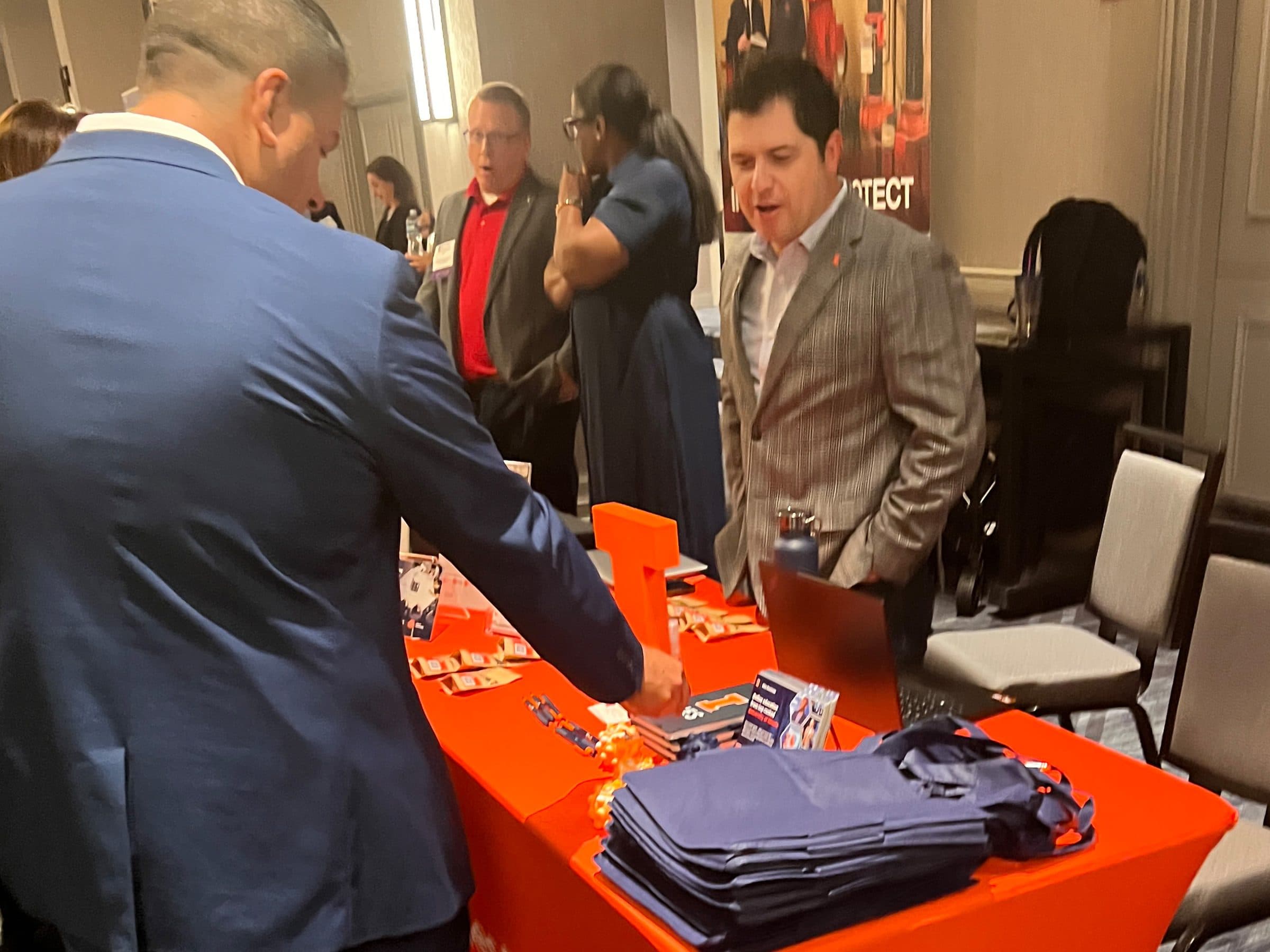 A visitor picks up materials at an exhibitor table in the expo.