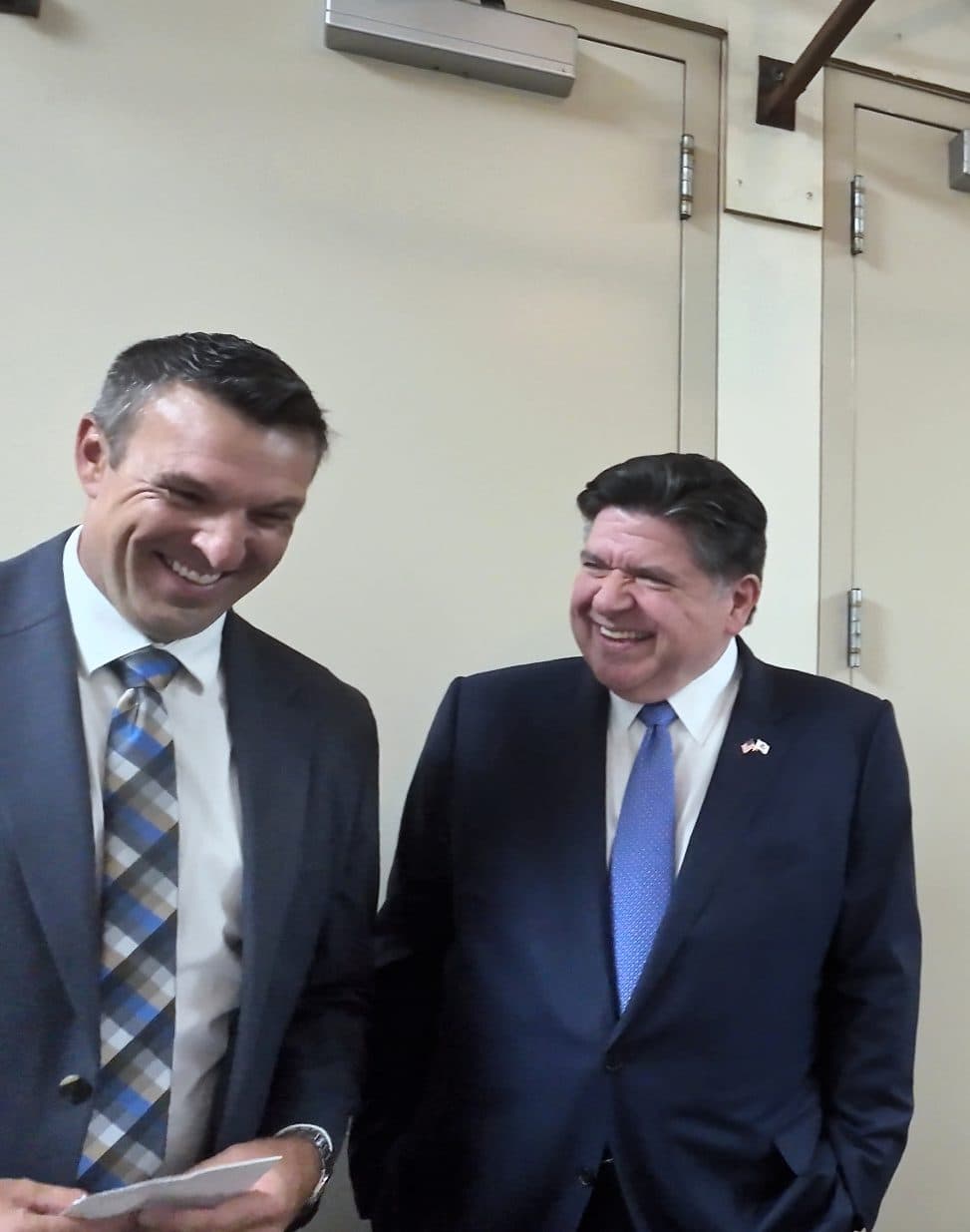 Two guests share a laugh in a hallway before the luncheon.