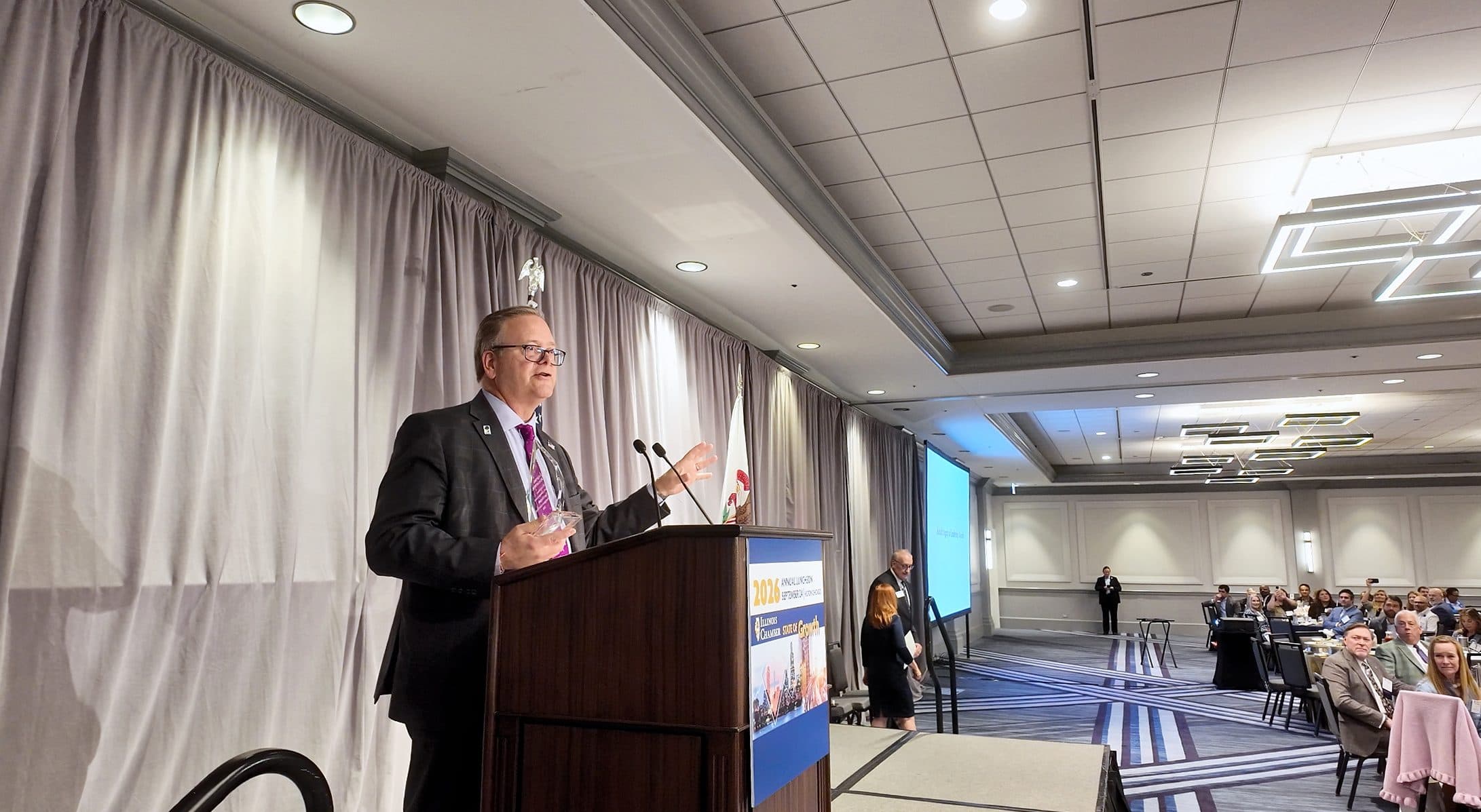 A speaker gestures while addressing the luncheon.